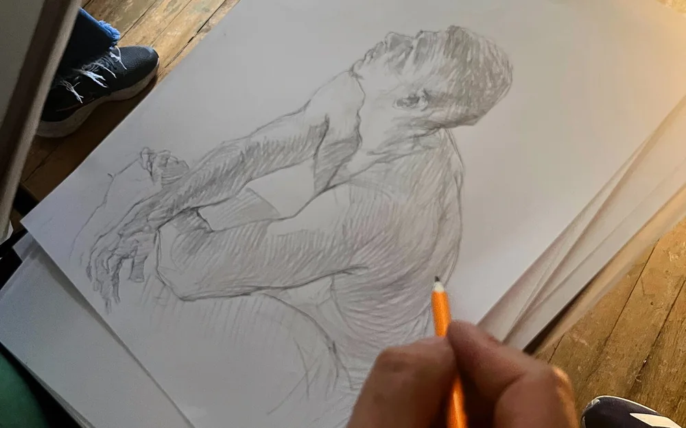Estudiante dibujando del natural en la sesión de modelo